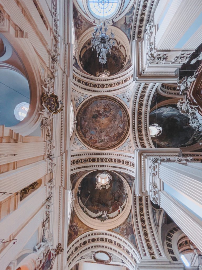 a ceiling with a statue and a clock